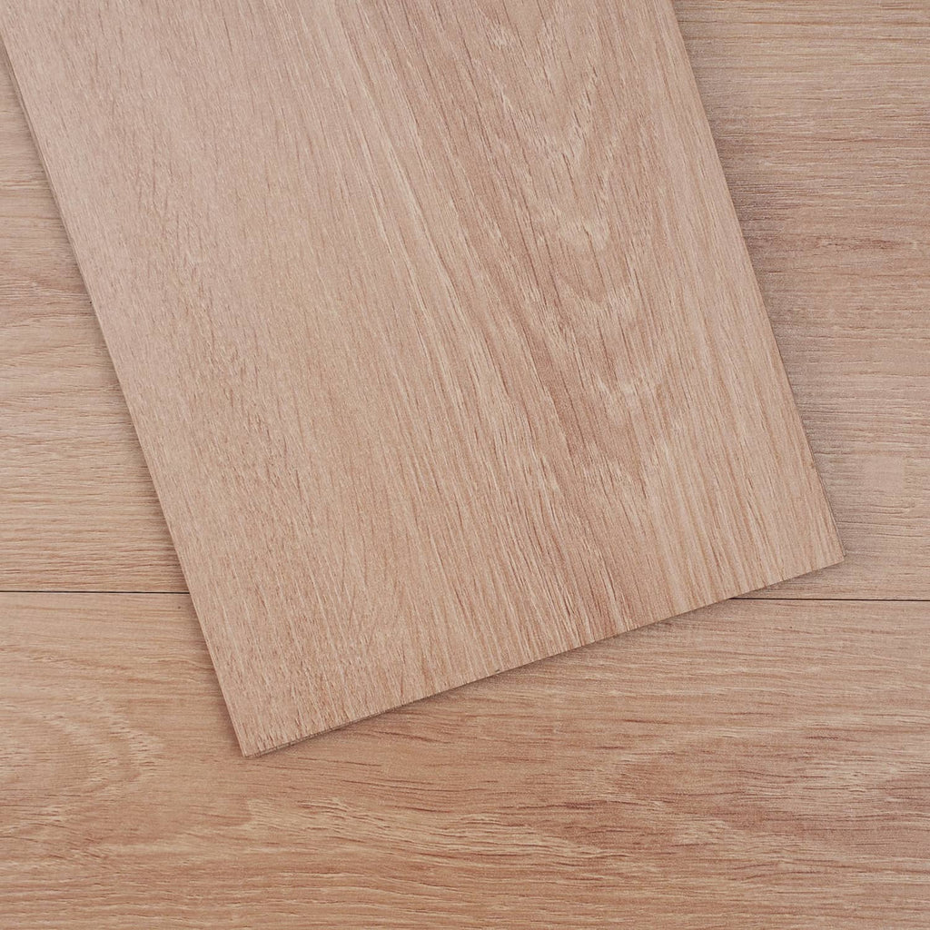 Close-up natural wood-grain vinyl floor tile with visible plank seam texture
