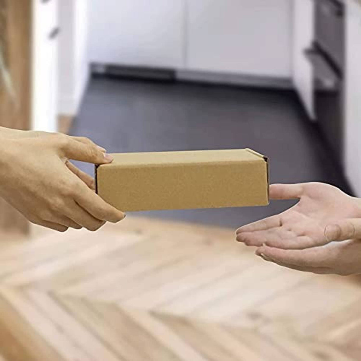 Small corrugated shipping box handed over with side flaps closed