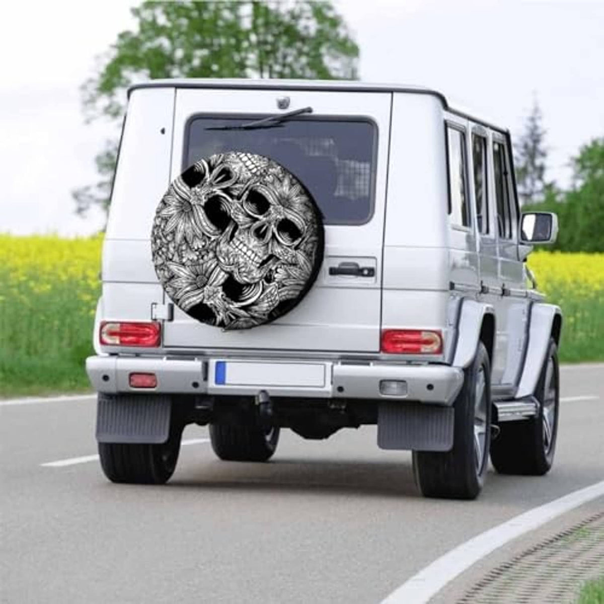 Skull spare tire cover on rear of white vehicle, detailed black-and-white skull artwork