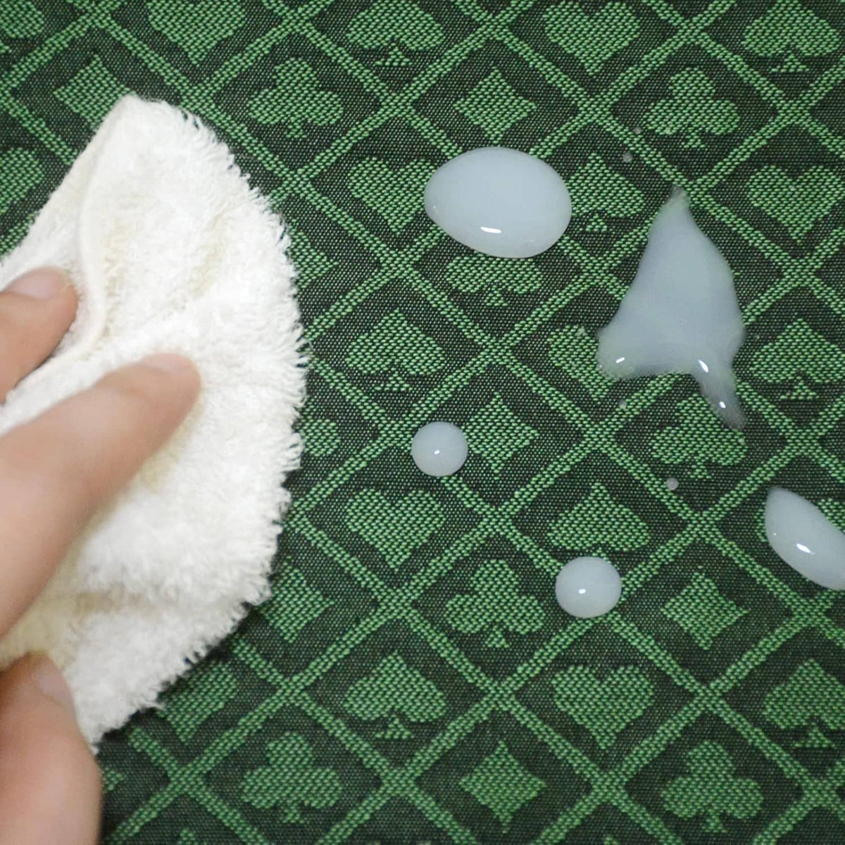 Green poker table speed cloth with diamond pattern; cleaning cloth and droplets