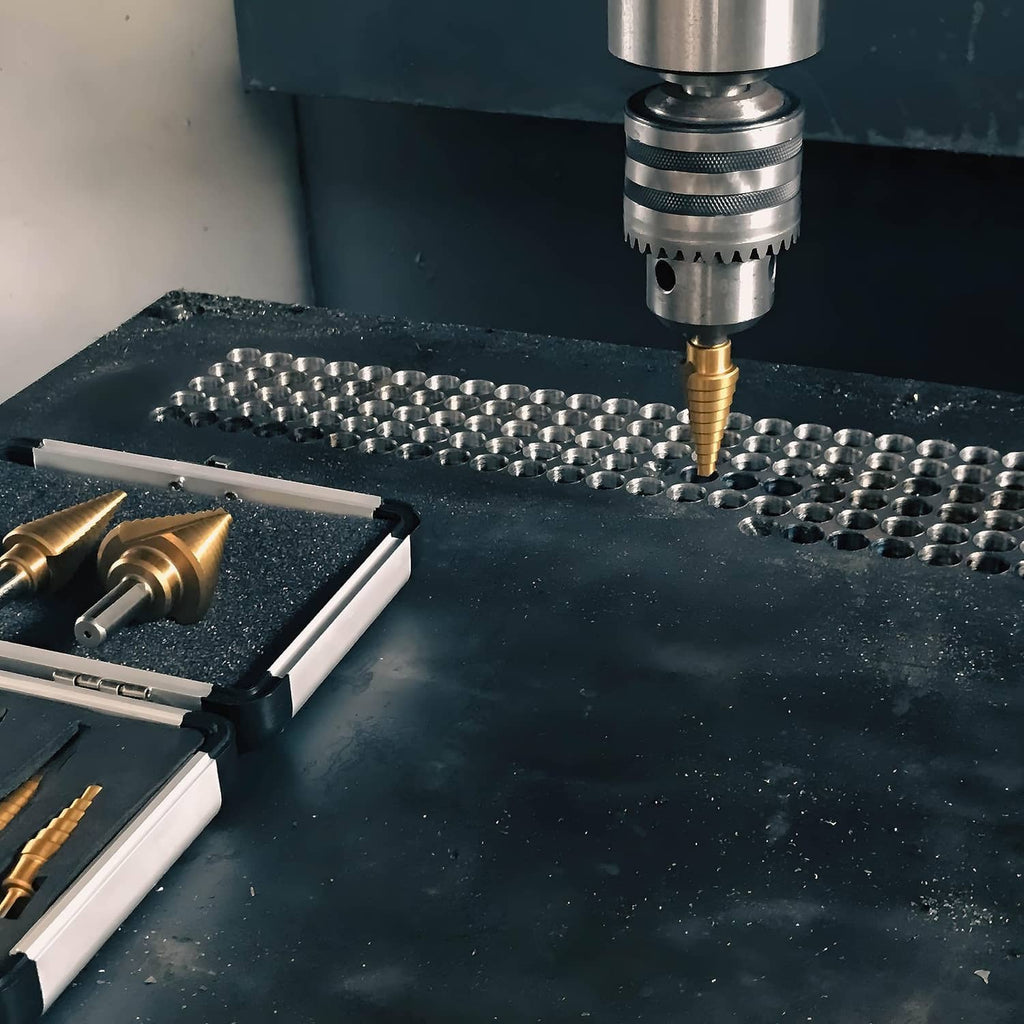 Step drill bit drilling into a metal grid surface under a machine chuck