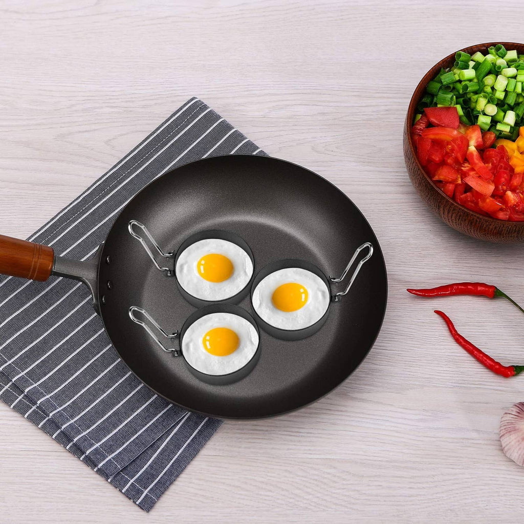 Nonstick skillet with three round egg cooking wells and three sunny-side eggs