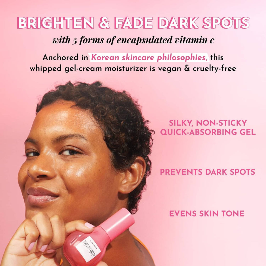 Pink dark spot serum bottle held near a woman's face, label visible