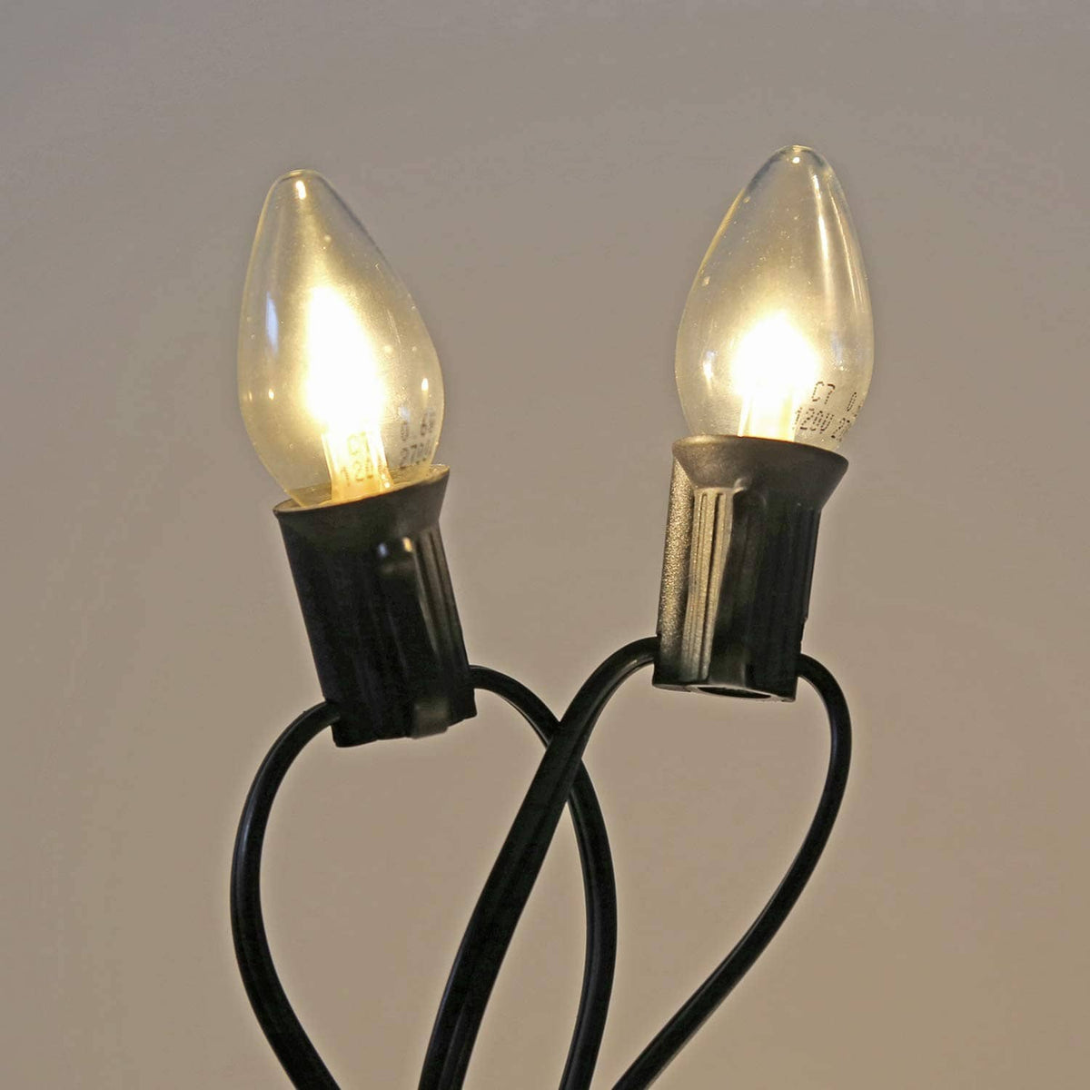 Candelabra LED bulbs in black socket holders with clear teardrop glass and warm glow