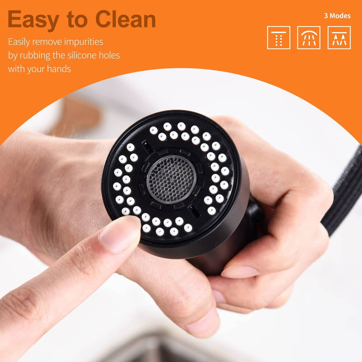 Matte black faucet head with circular nozzle face; hands cleaning silicone spray holes