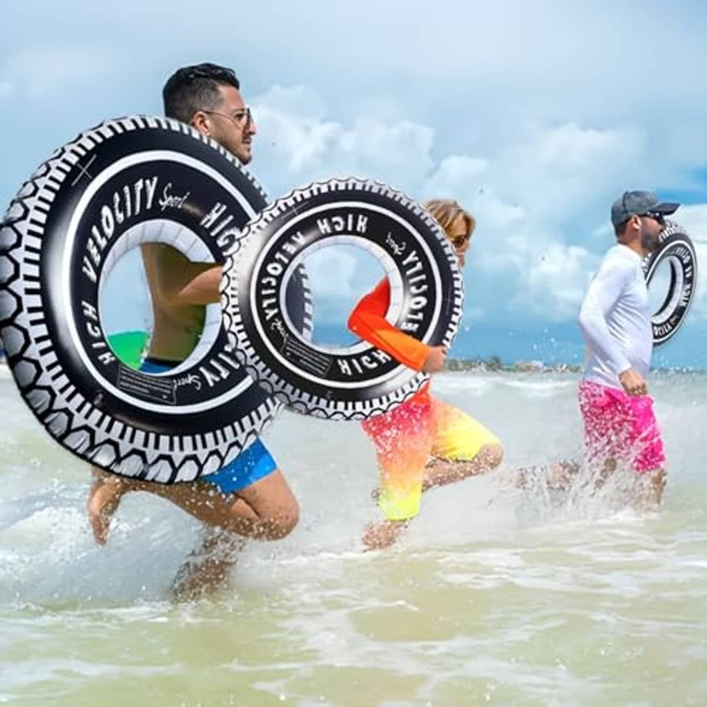 Two black-and-white inflatable tire pool float rings with “High Velocity” lettering
