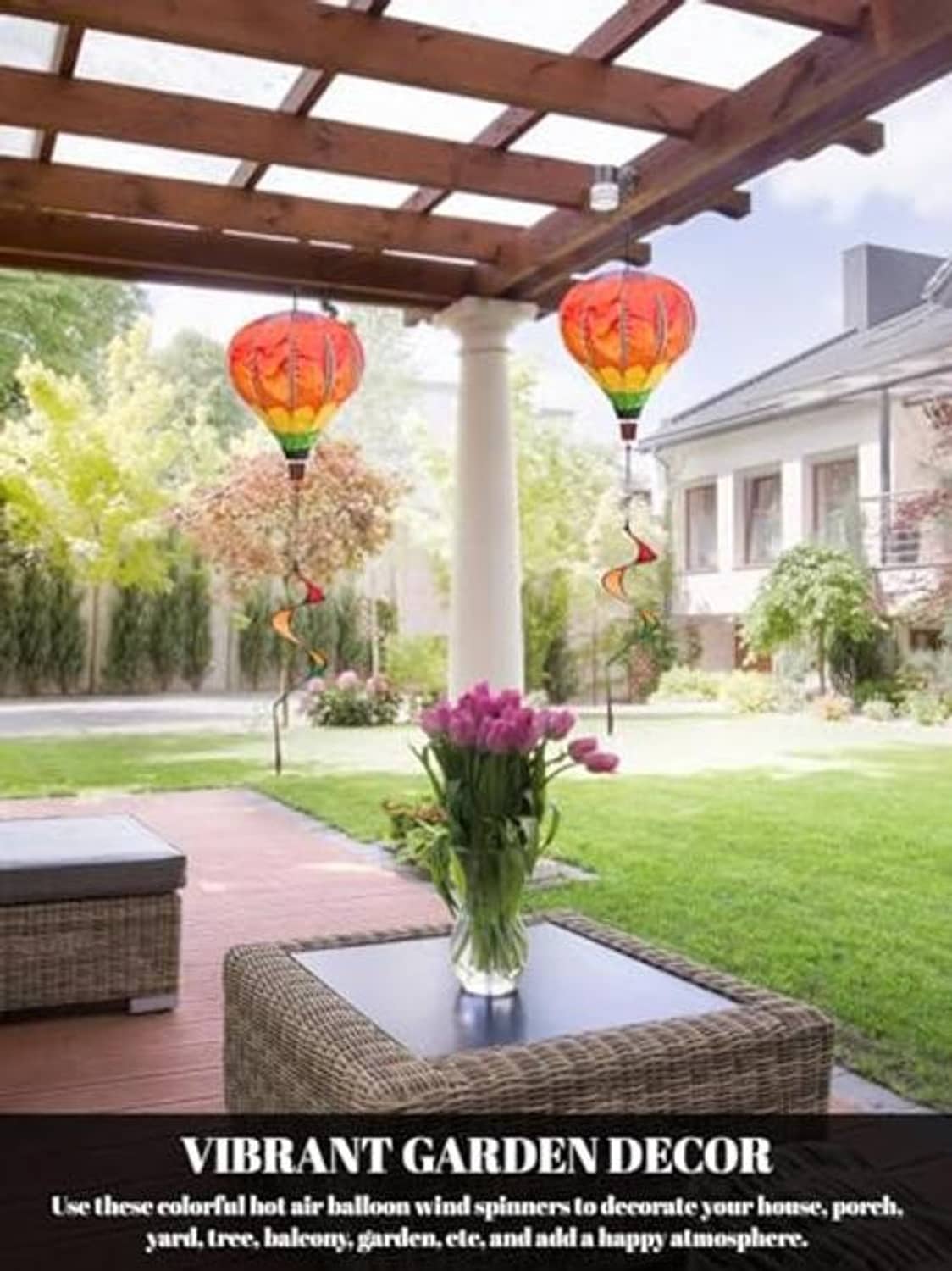 Rainbow hot air balloon wind spinner pair hanging outdoors with swirled ribbon tails