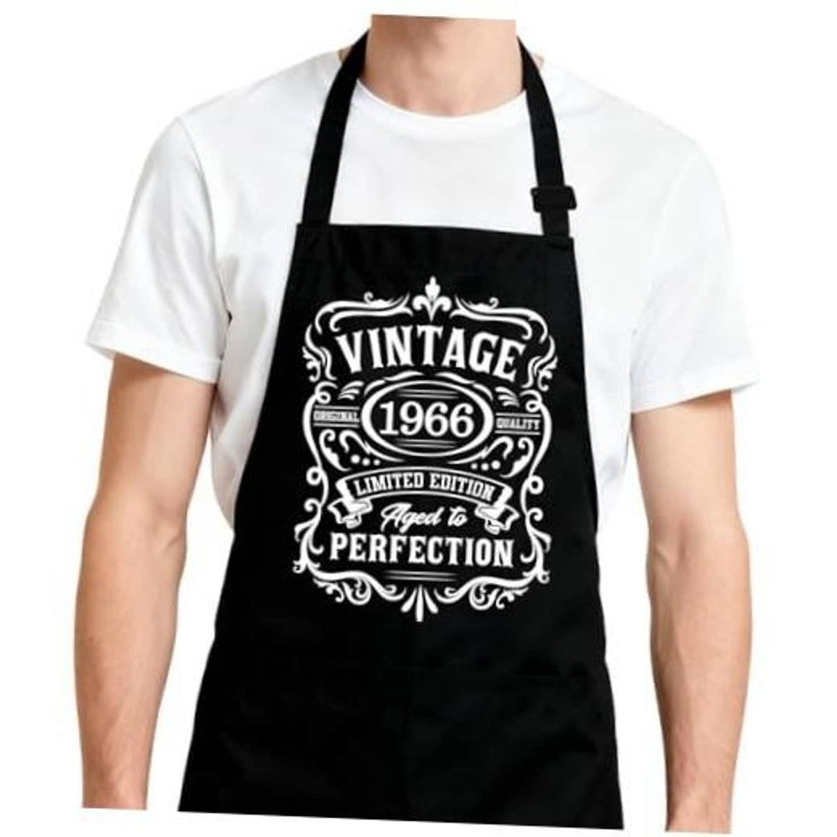 Black apron with adjustable neck strap and large vintage-style front logo patch.