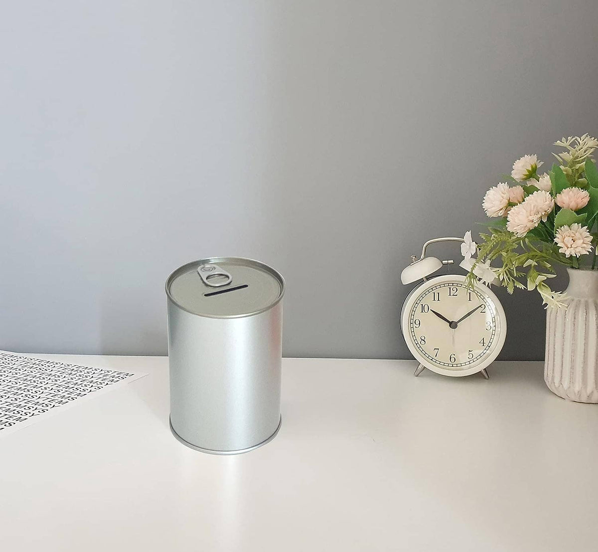 Small silver metal coin piggy bank with pull-tab lid and coin slot