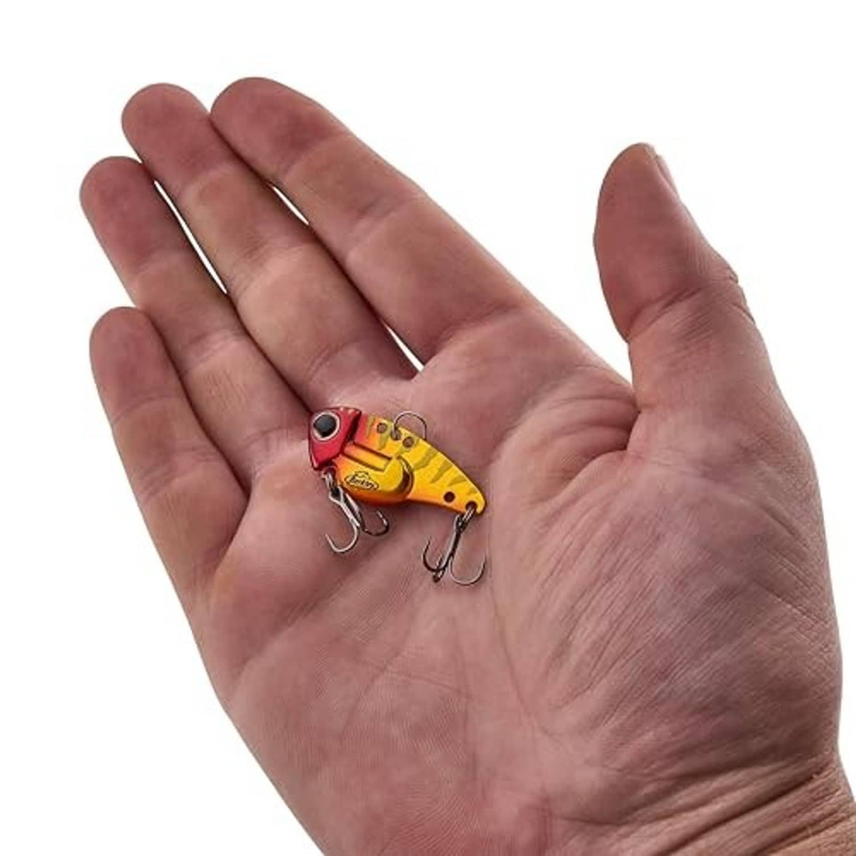Gold and red blade bait fishing lure held on an open palm