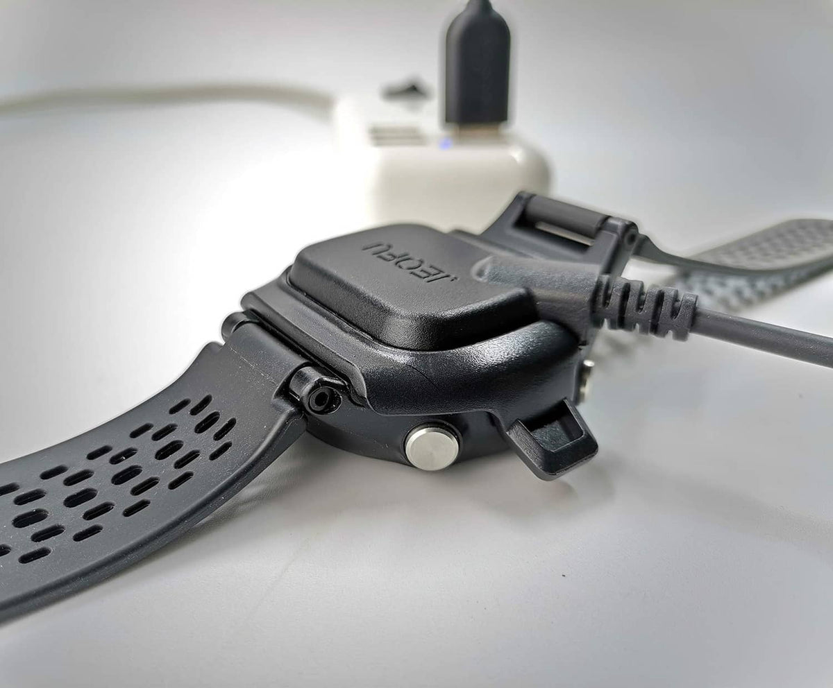 Black charging dock and cable connector attached to Garmin watch