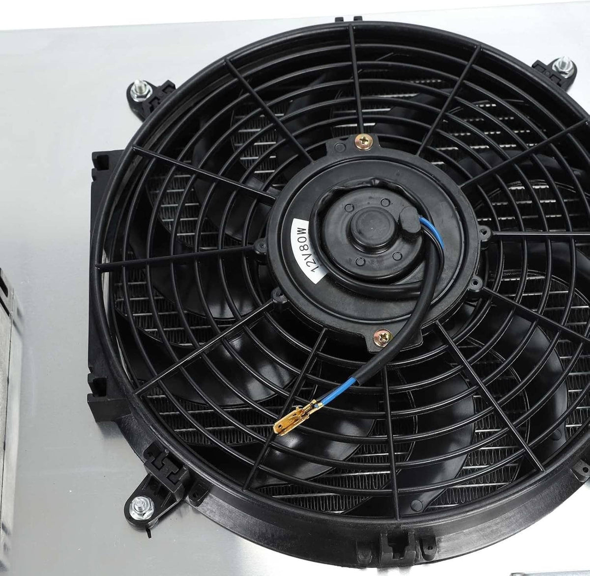 Close-up of black radiator fan motor with mounting ring and wiring