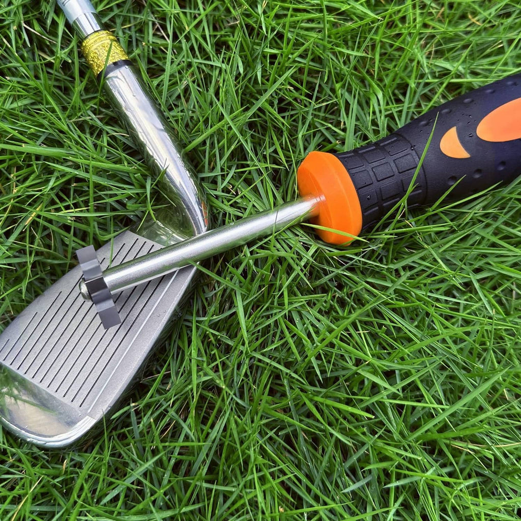 Golf club groove sharpener with metal shaft and orange grip on grass