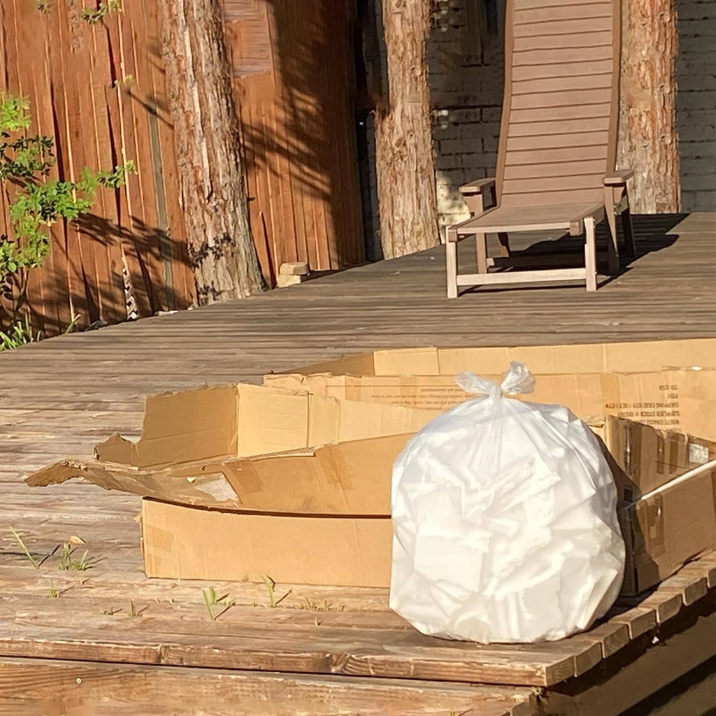 Clear trash bag liners wrapped in plastic, packed boxes on wooden deck