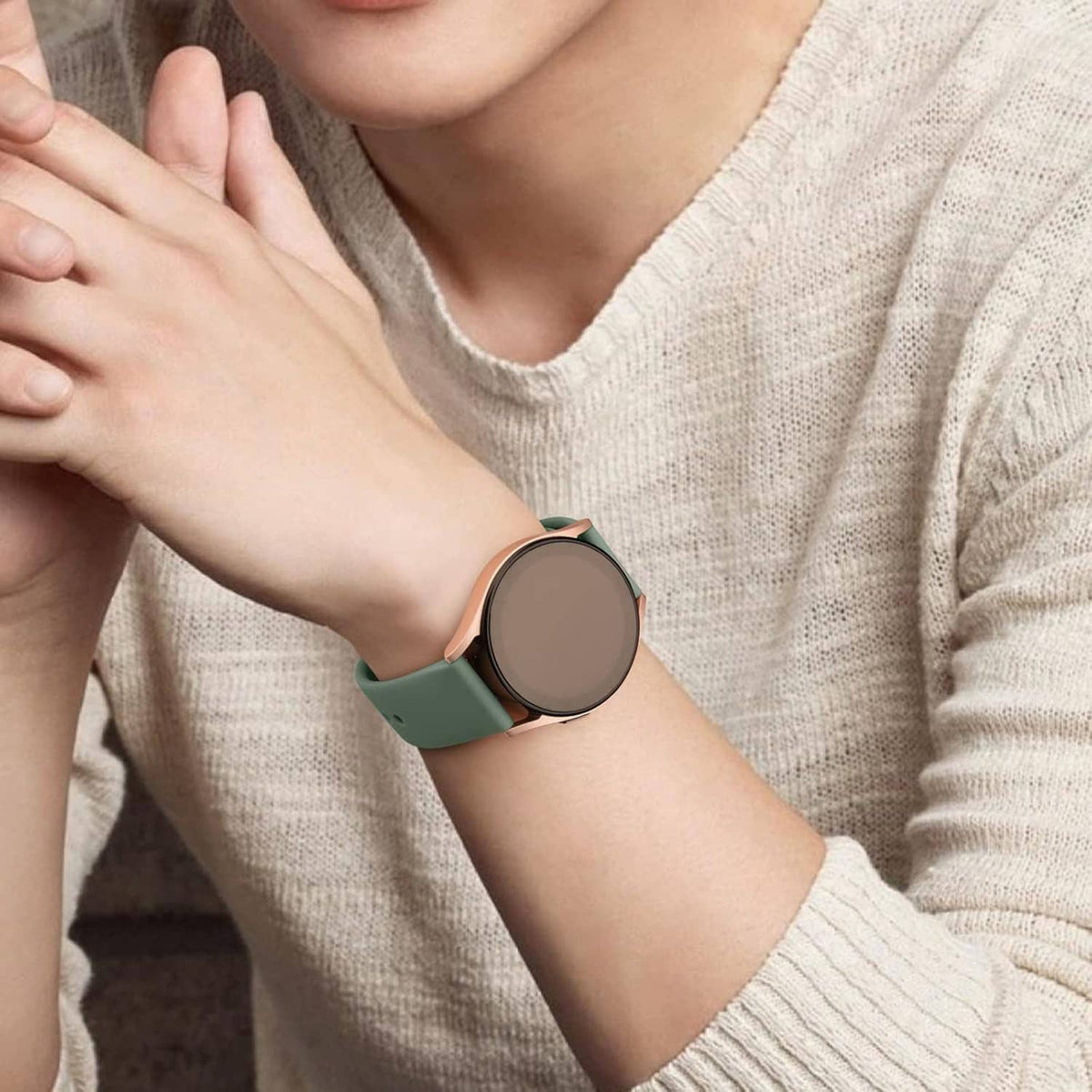 Green silicone watch band on smartwatch, round clasp and strap pin holes visible