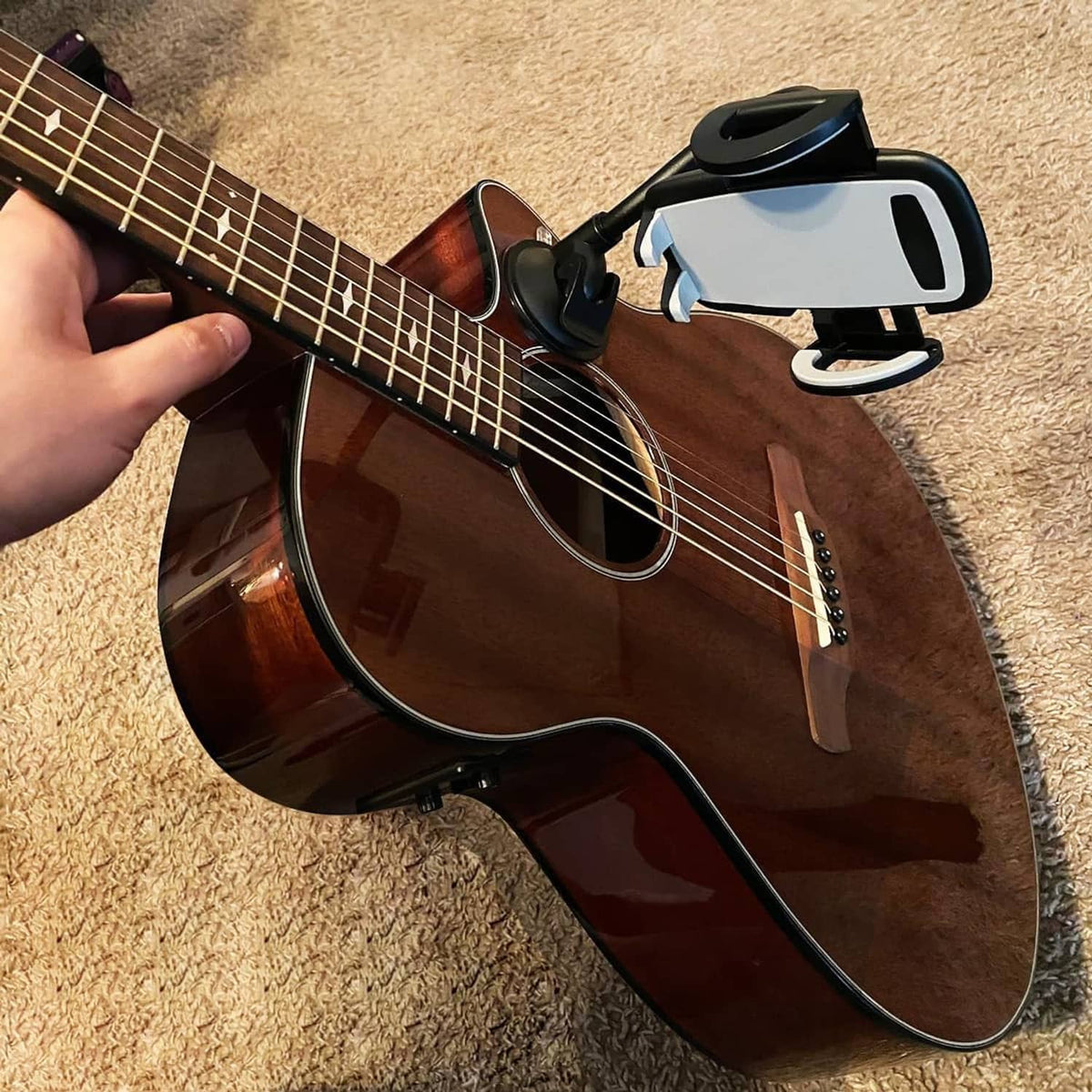 Black phone holder clamp on guitar with gooseneck suction mount