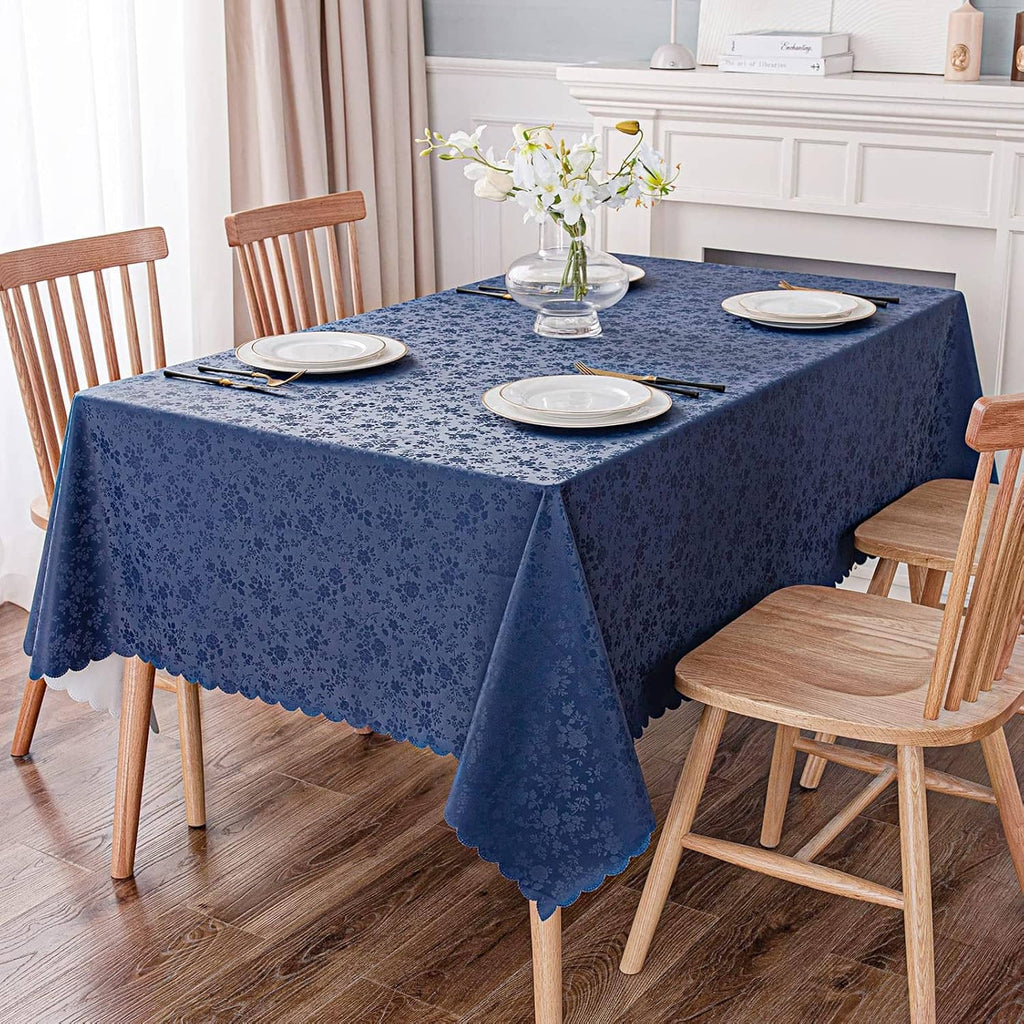 Blue floral vinyl tablecloth on dining table with dishes and a vase of flowers