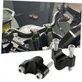 Black handlebar riser mount clamps with silver bolts for motorcycle handlebar height