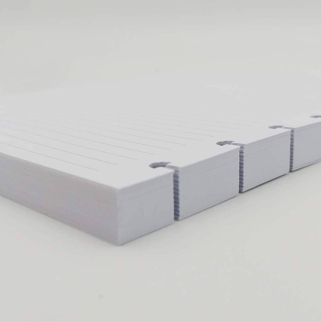 Stack of white lined A5 disc refill paper with blue edge binding marks