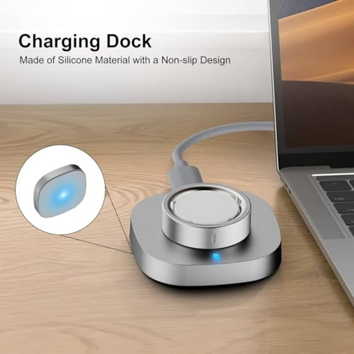 Grey charging dock with circular cradle and blue indicator light beside laptop