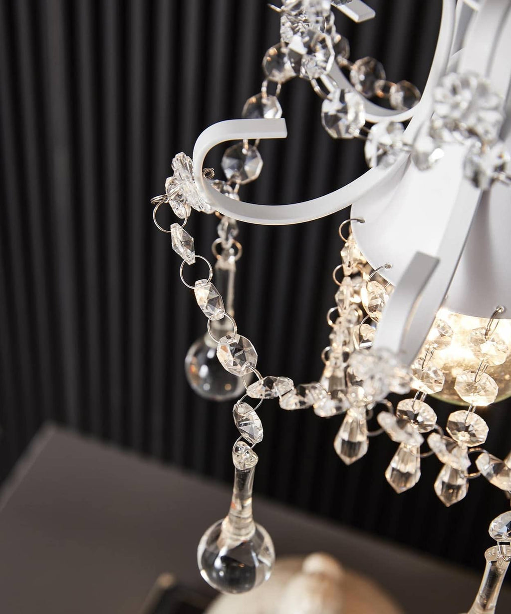 Crystal chandelier pendant light close-up with faceted drops and white metal arms