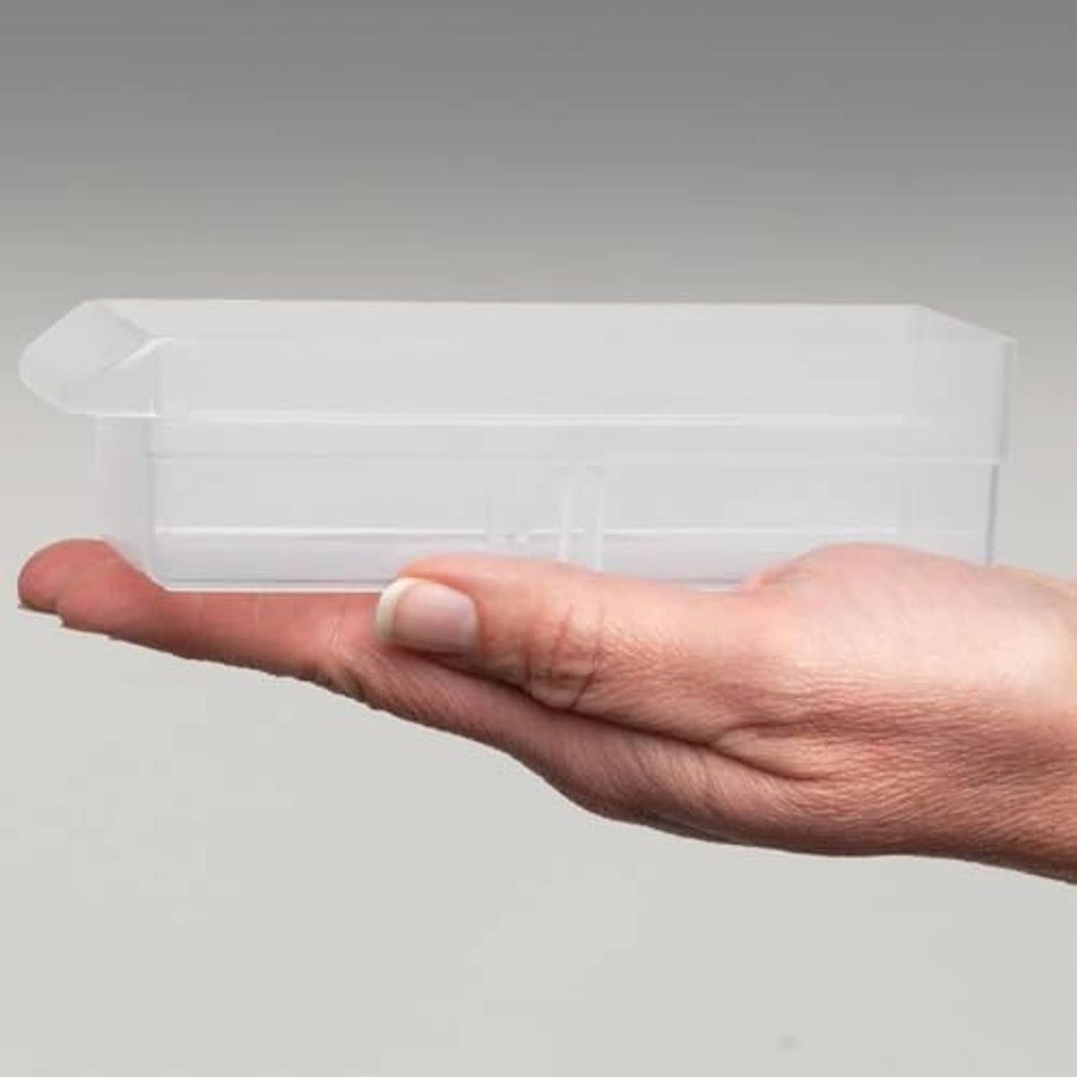 Hand holding a white plastic drawer insert or bin