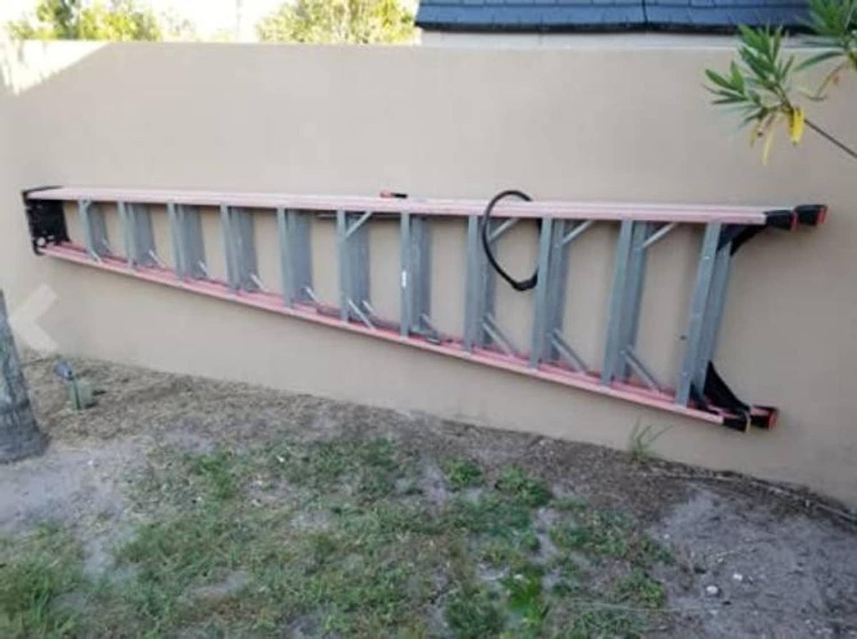 Wall-mounted ladder organizer bar with hanging ladder supports