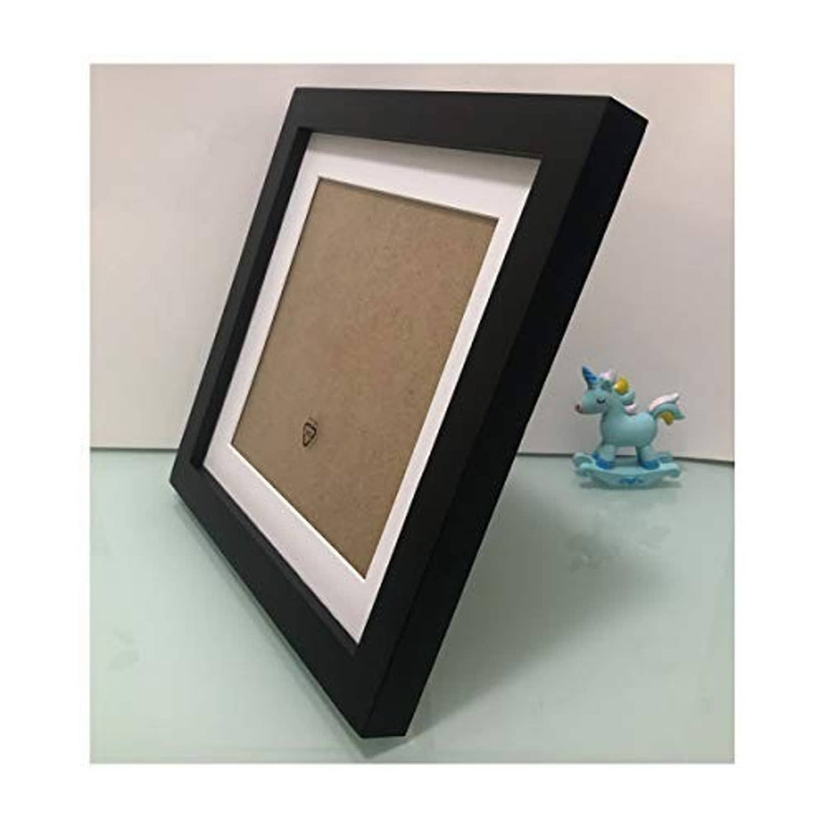 Black square wooden picture frame with white mat, showing cork backing from the side