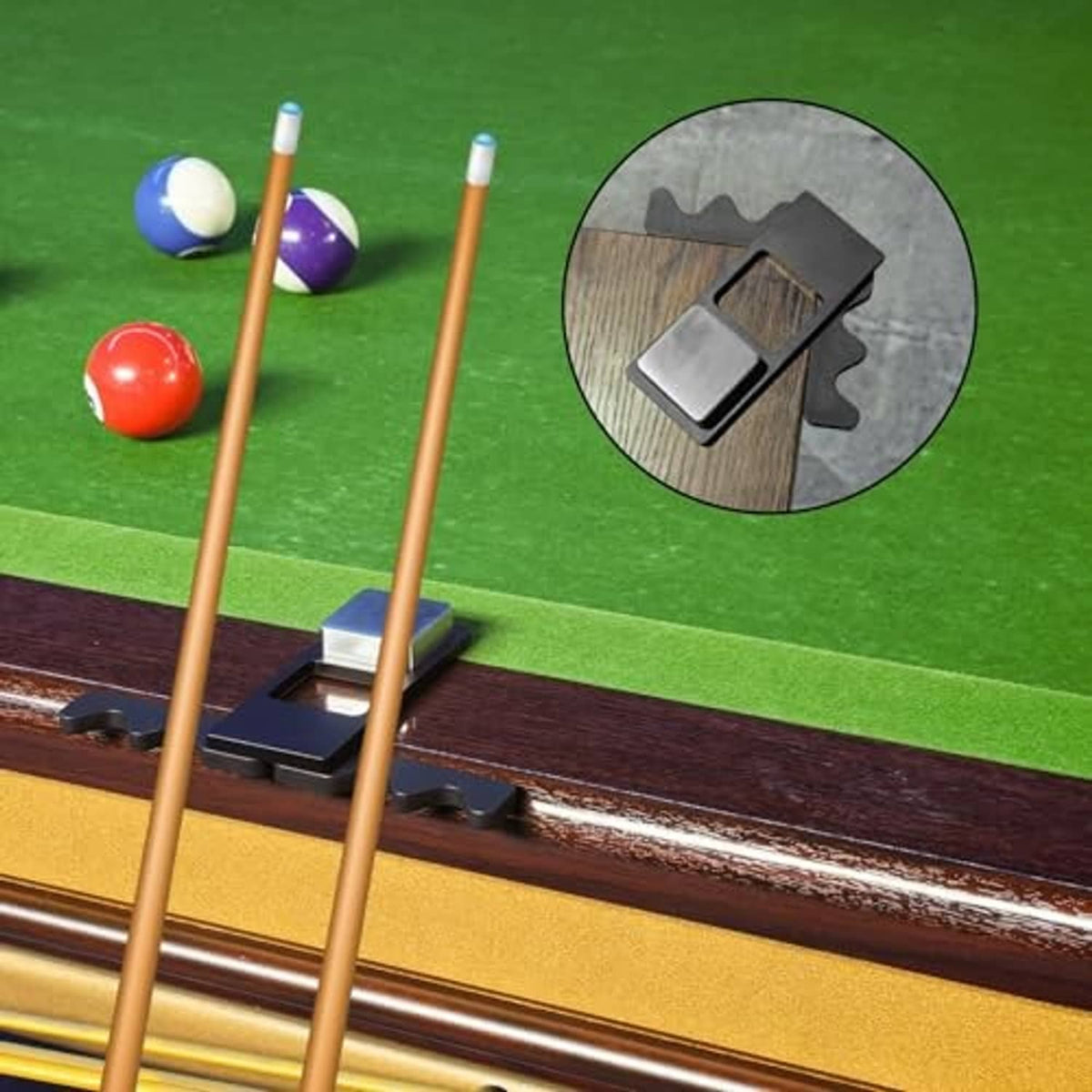 Black pool stick holder gripping four cues on a billiard table, angled view