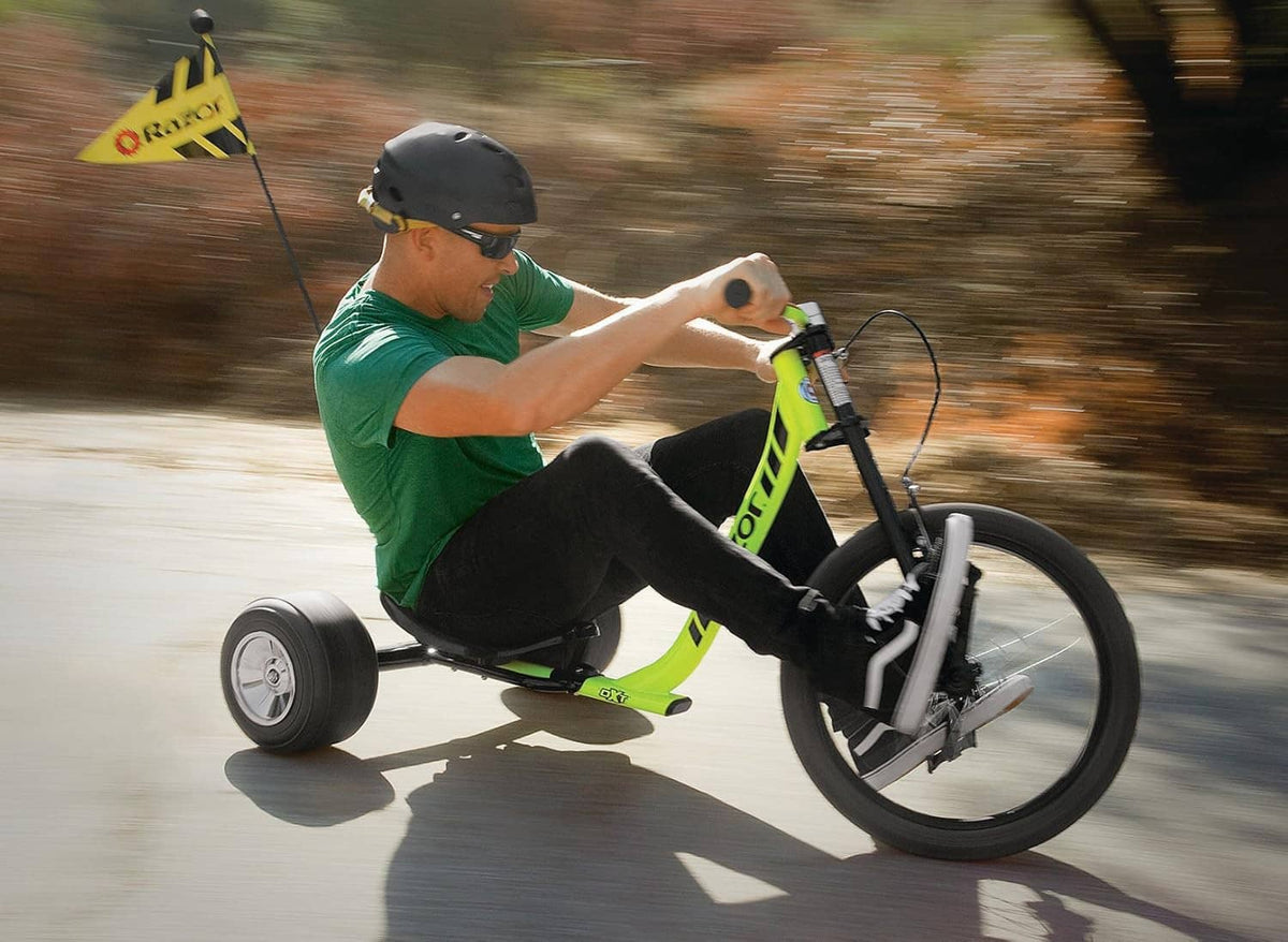 Neon yellow drift trike ridden outdoors with a helmeted driver
