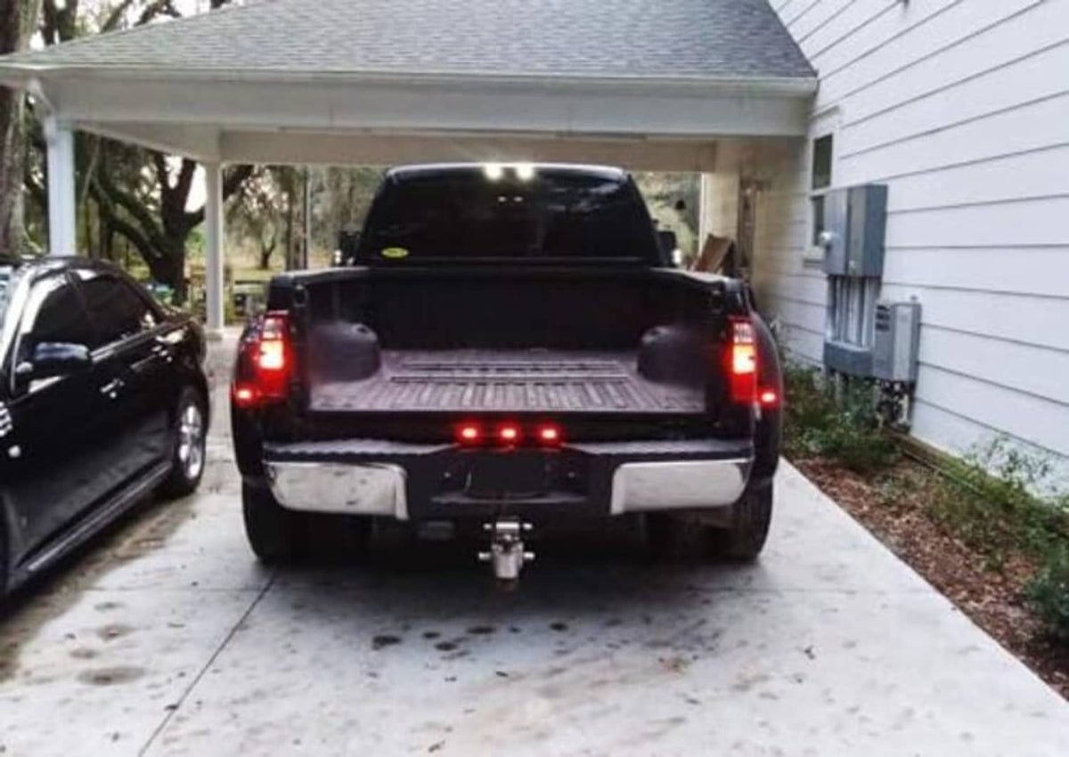 Truck rear tailgate LED ID light bar with three red lights glowing