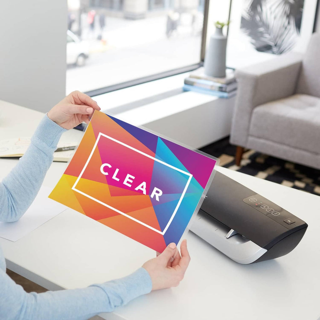 Clear laminating pouch with 'CLEAR' design being inserted into a laminator