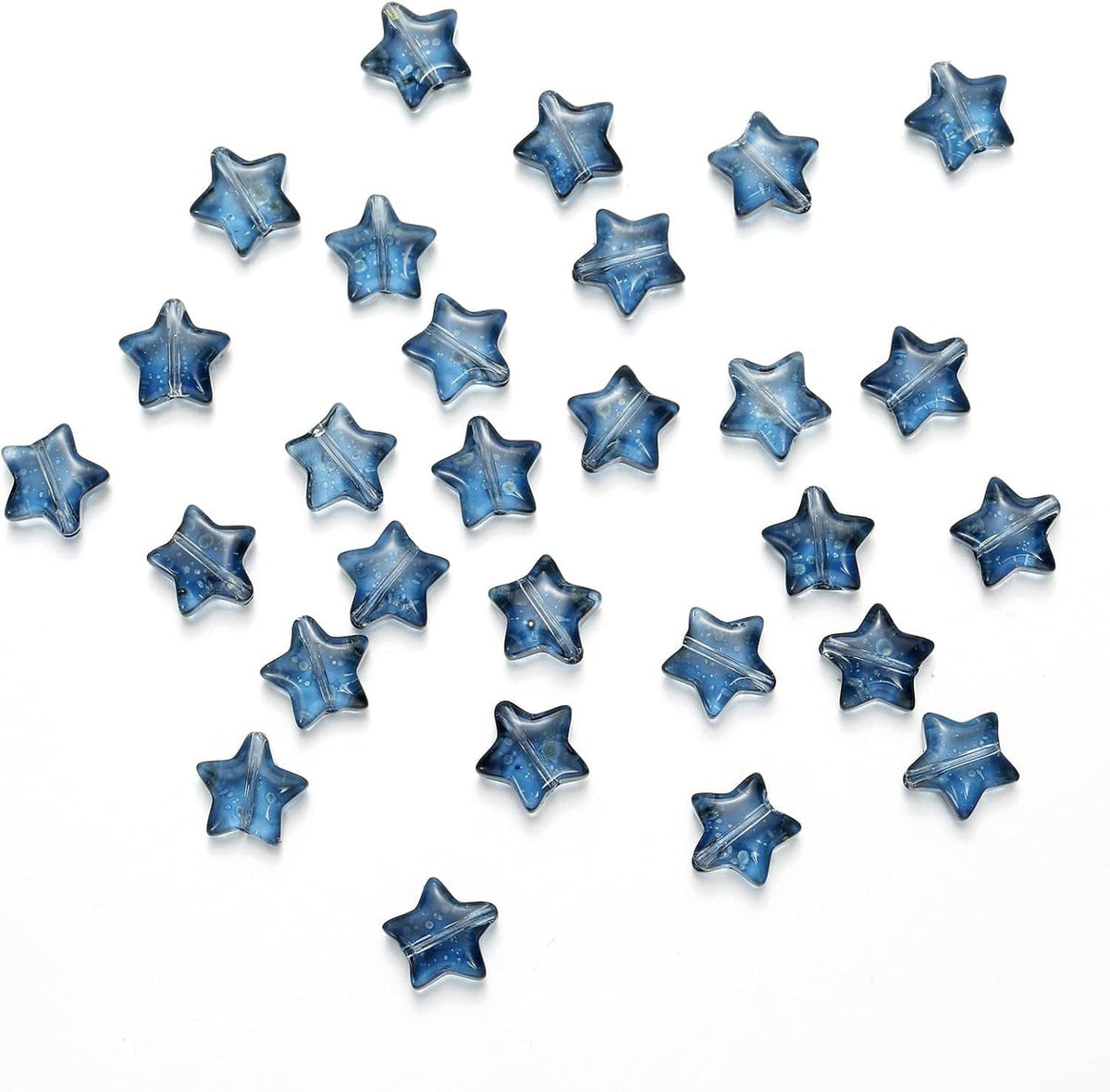 Dark blue star glass spacer beads scattered on a white surface