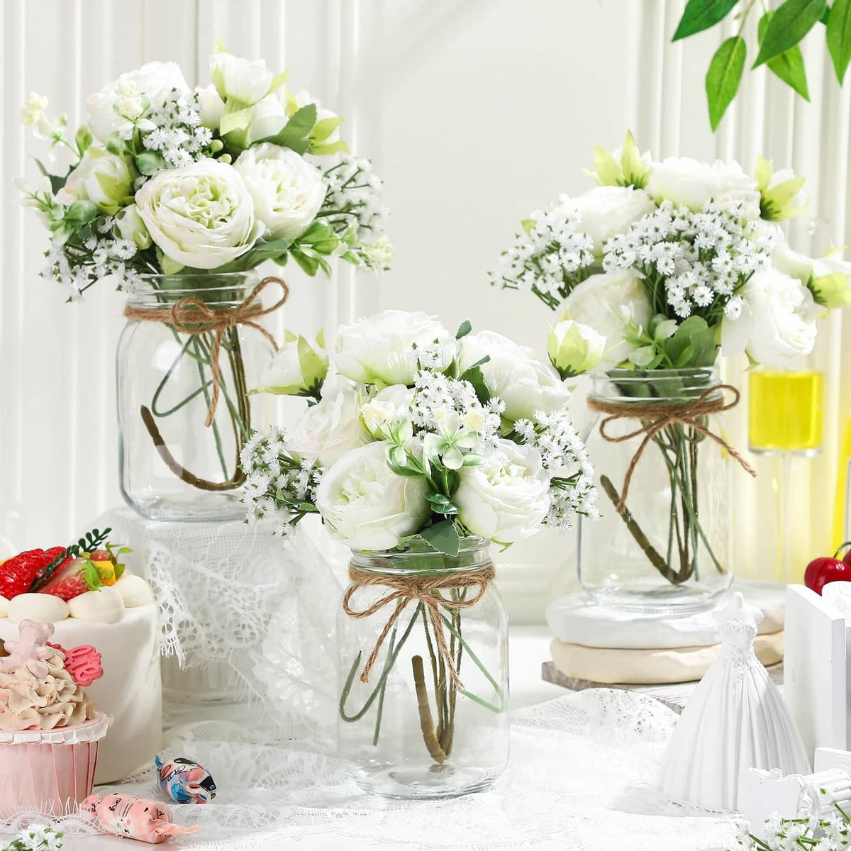 Artificial flower centerpiece set with three mason jars of white roses and greenery