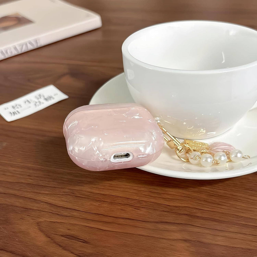Pink glitter TPU AirPods case with pearl keychain charm, side view showing charging port