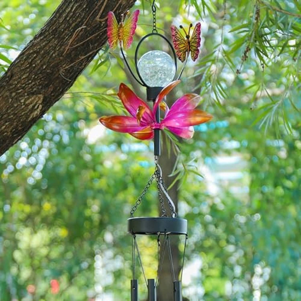 Close-up solar metal wind chime with butterfly accents, flower spinner, and crackle globe