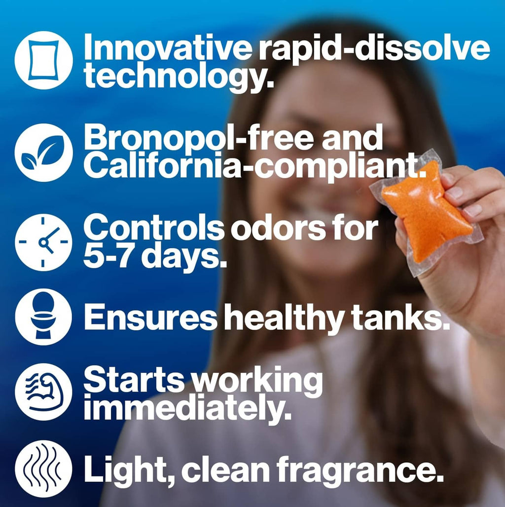 Hand holding an orange Citra-Pak toilet treatment drop-in packet for RV tanks