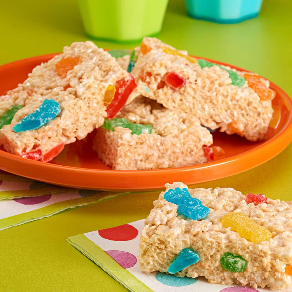 Frosted snack clusters with colorful gummy bits on an orange plate