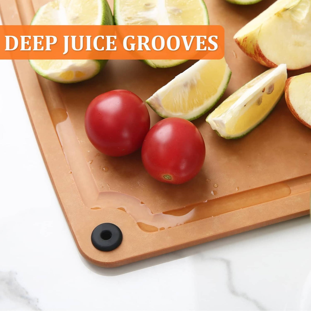 Tan composite cutting board with juice grooves, tomatoes and lemon wedges nearby