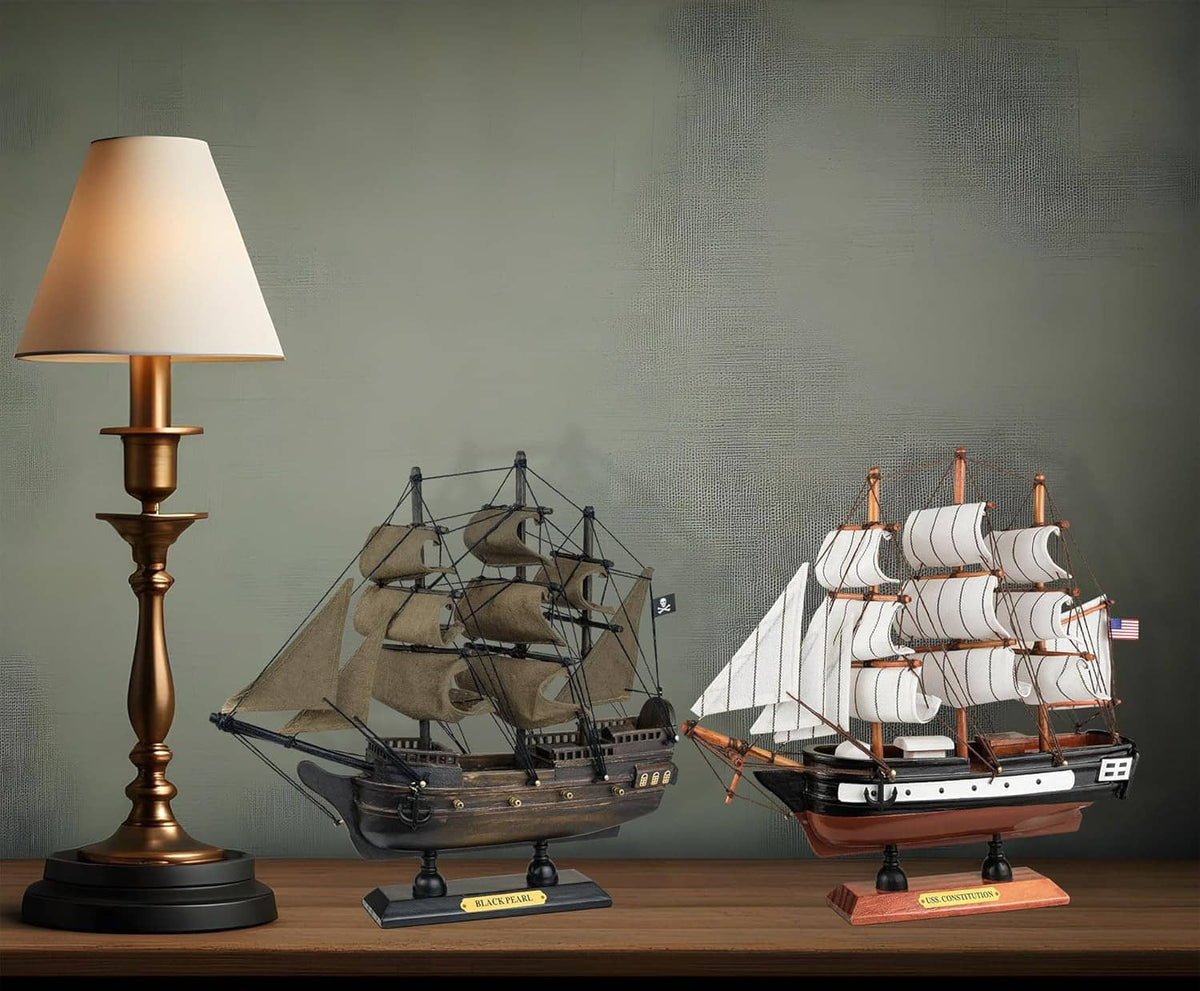 Wooden ship models on stands, dark pirate ship and white sail ship