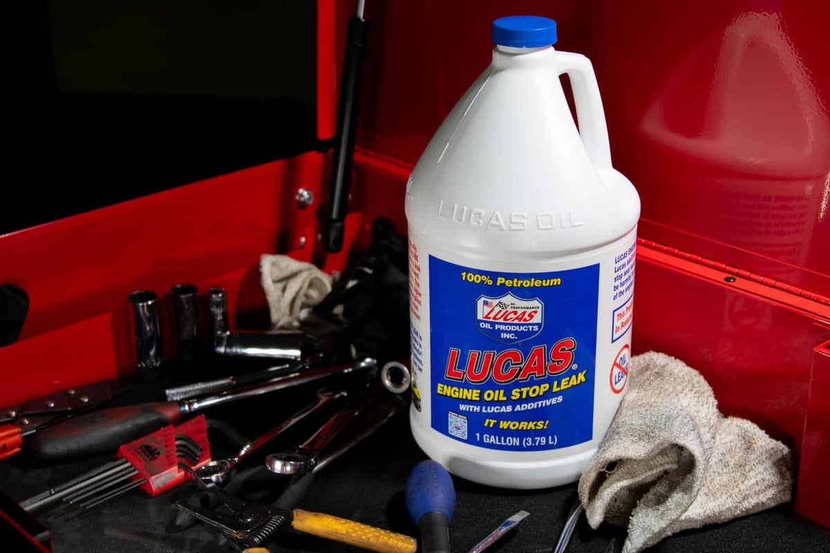 Lucas Oil engine oil stop leak bottle on a garage tools surface, blue label