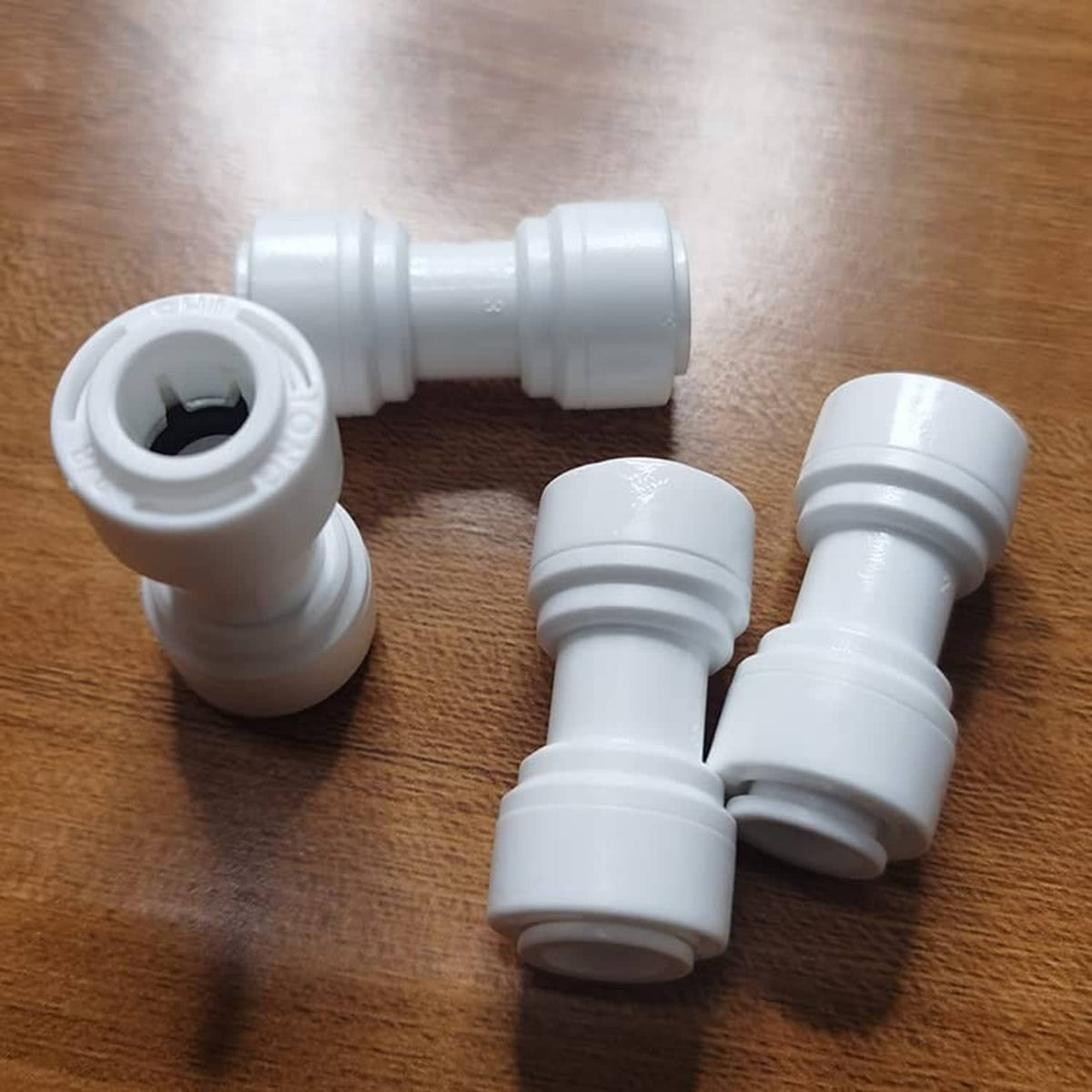 White push-fit 3/8 in O.D. tube elbows with molded grip rings at ends