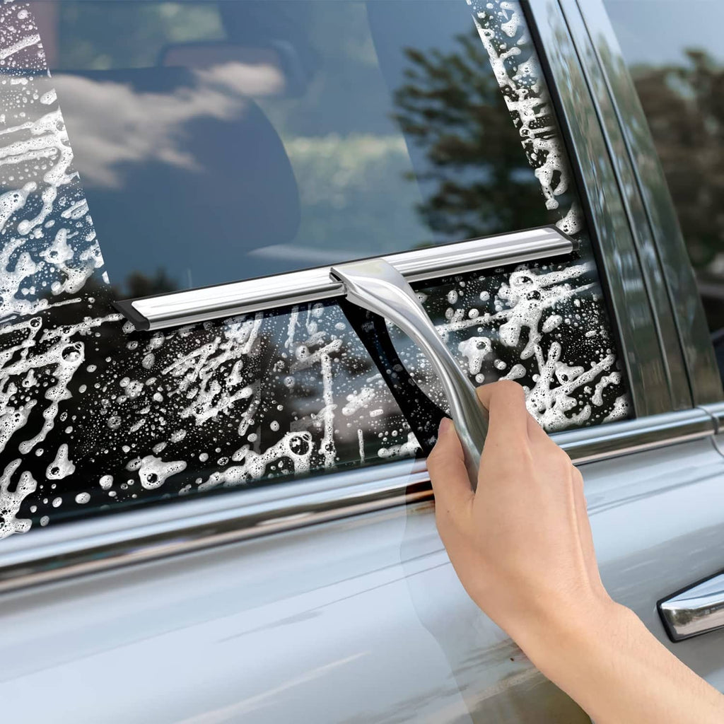 Stainless steel squeegee wiping water from a car windshield with angled blade.
