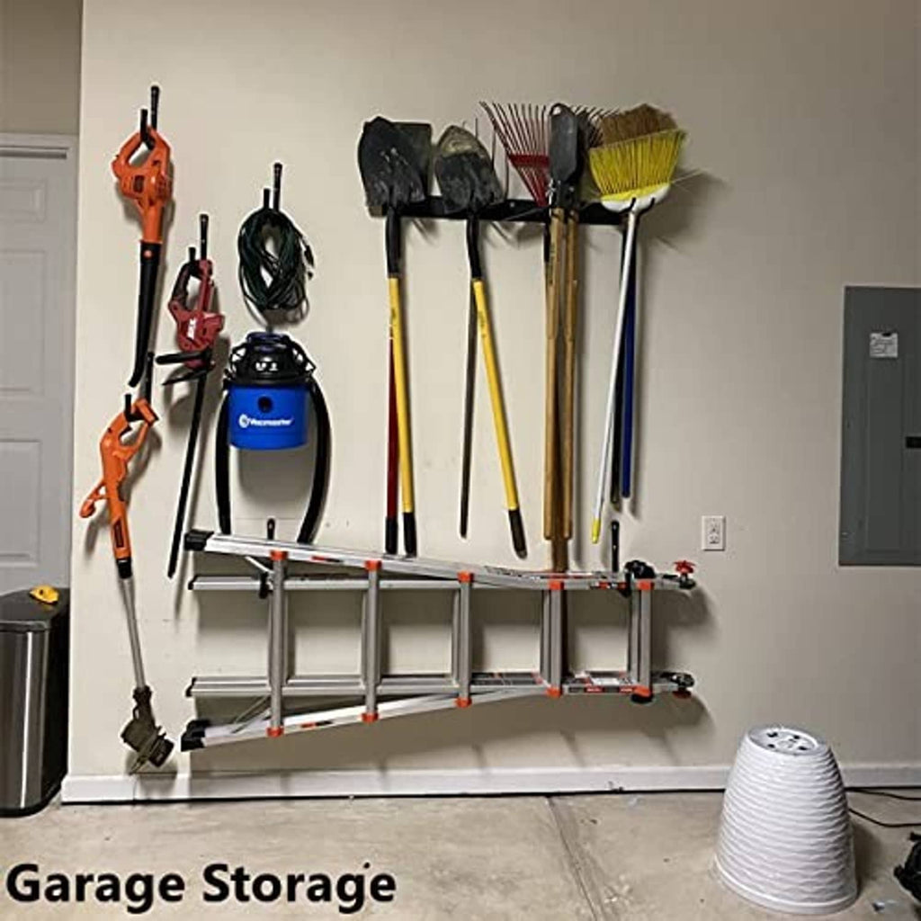 Wall-mounted black ladder hooks holding brooms, shovels, and yard tools