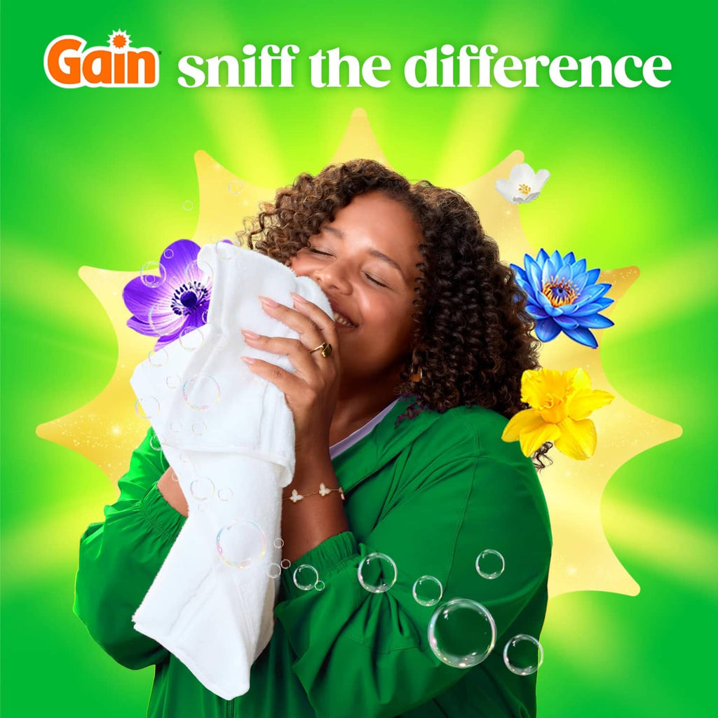 Smiling person holding white laundry with detergent bubbles and flowers
