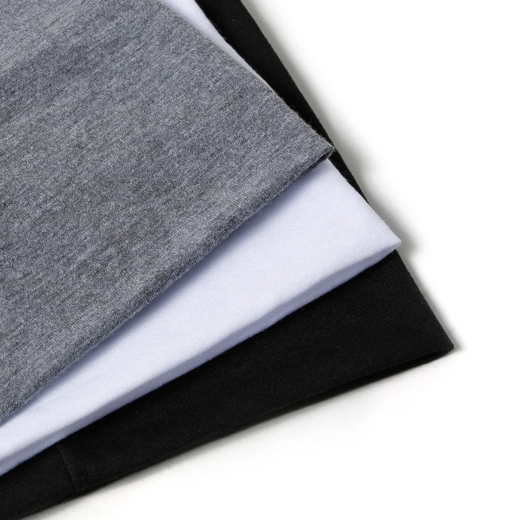 Stacked wide elastic headbands in light gray, white, and black.
