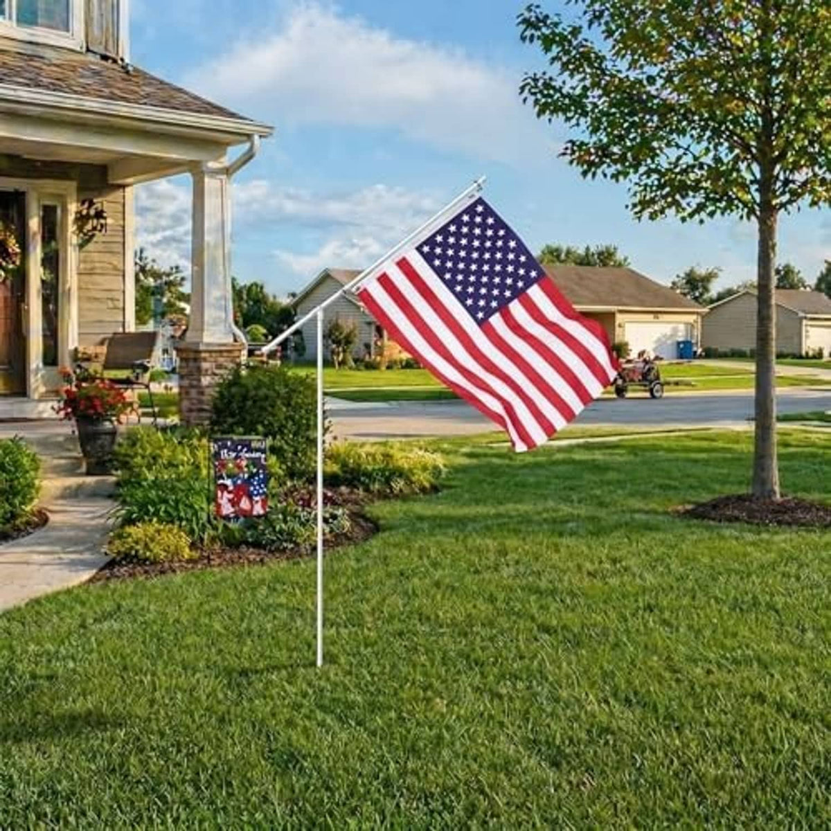 American flag on a white telescoping pole with ground stake, positioned outdoors