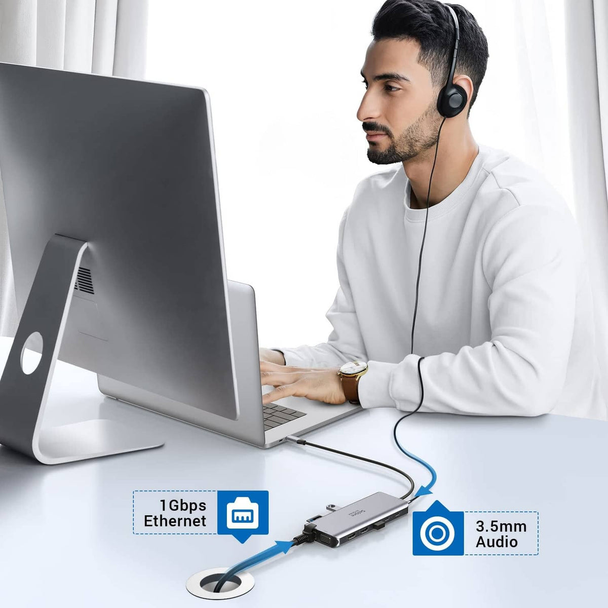 Silver USB-C dock used with a laptop and headphones for audio and network access