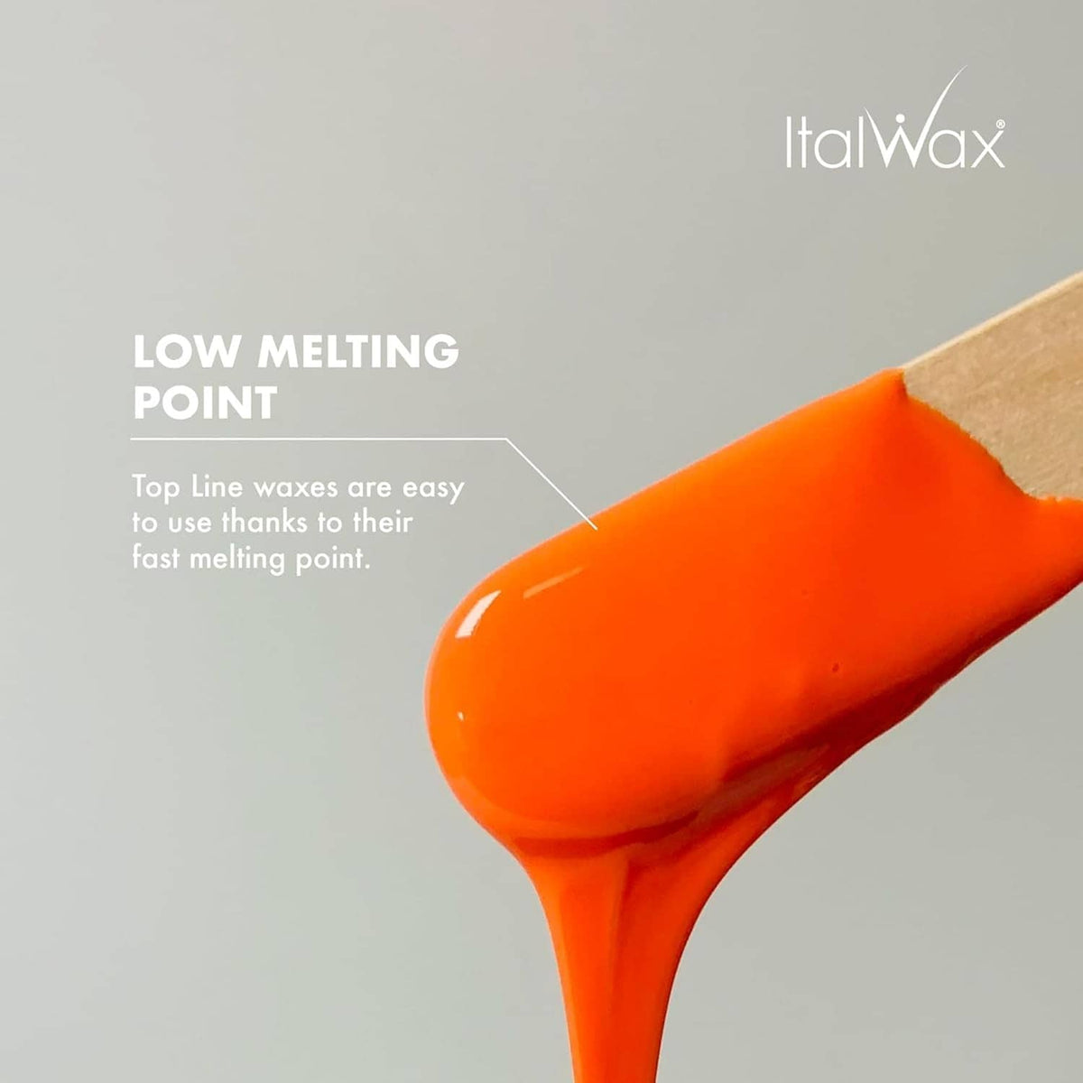 Coral hard wax on a spatula, glossy orange texture for low melting point use.