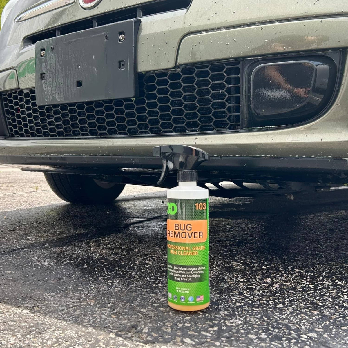 3D bug remover spray bottle hanging under a car bumper, green and orange label